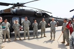 Members of a medical evacuation flight crew from the 3rd Battalion, 126th Aviation Regiment (Air Ambulance), an Army National Guard unit based in Westfield, Mass., and Burlington, Vt., stand at parade rest in front of their HH-60M Black Hawk helicopter on Camp Taji, Iraq on Aug. 11, 2011. Army Lt. Gen. Frank Helmick, deputy commanding general for U.S. Forces-Iraq, addresses a crowd of onlookers before presenting the crew with Air Medals for conducting two aerial medical evacuations during a dust storm on June 30. The crew, from left, is Chief Warrant Officer 4 John Labbe, Chief Warrant Officer 2 Alex Engelson, Staff Sgt. Richard Flach, Sgt. Cassandra Kennedy and Pfc. Corey Davis.