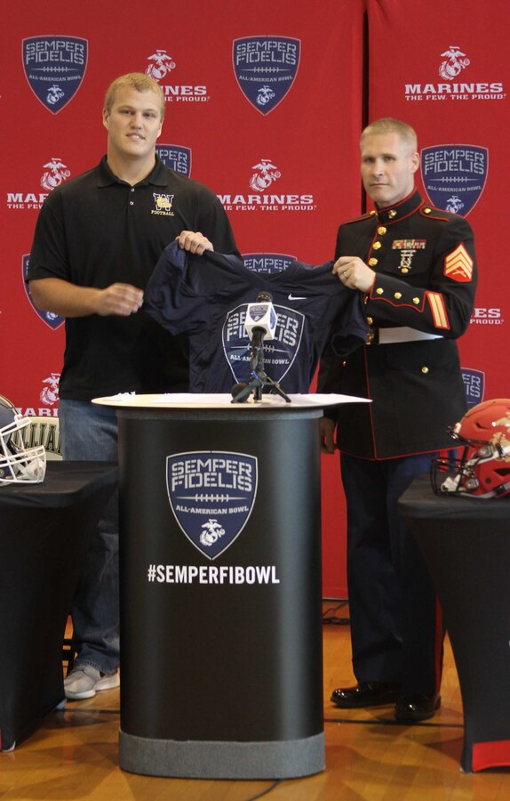 U.S. Marine Corps Sgt. Daniel P. Greer, a recruiter with Marine Corps Recruiting Sub-station Durham, speaks during a Semper Fidelis All-American Bowl jersey presentation for Harrison Gee, an offensive guard for the Williams High School football team, at Williams High School in Burlington, North Carolina, Oct. 23, 2015. Gee was selected to play in the bowl for his skill as an offensive guard, his academics and his leadership ability.  The Semper Fidelis All-American Bowl allows the Marine Corps to purposefully engage with well-rounded student athletes and share leadership lessons that will enable future success. It will be played on Jan. 3, 2016, in Carson, California, and will be broadcast on Fox Sports 1. (U.S. Marine Corps photo by Sgt. Dwight A. Henderson/Released) 