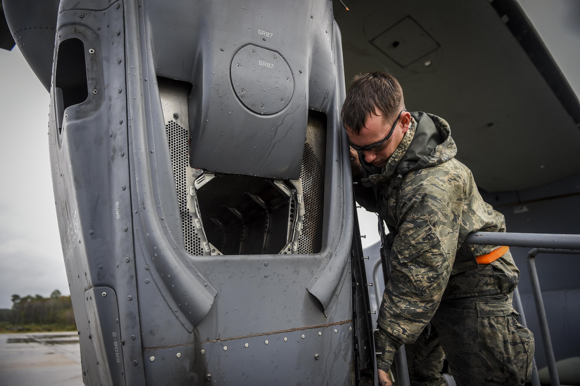 Senior Airman Braden Ferrell, 801st Special Operations Aircraft Maintenance Squadron crew chief, positions an infrared deflector panel back on to a CV-22B Osprey during routine maintenance at Hurlburt Field, Fla., Oct. 27, 2015. Despite the after-effects of Hurricane Patricia, crew chiefs with the 801st SOAXMS continued performing maintenance to accomplish the mission. (U.S. Air Force photo by Senior Airman Christopher Callaway/Released)
