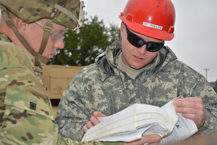 Pfc. Tristen Cain, an active duty wheeled vehicle mechanic assigned to 2nd Brigade, 112th Infantry Division, Fort Carson, Colo., and Sgt. 1st Class Timothy Phillips, a Wheeled Vehicle Recovery Course instructor assigned Regional Training Site Maintenance-Fort Hood, Texas, reference a training manual during the Wheeled Vehicle Recovery Course, Oct. 22, 2015. The course teaches Army mechanics how to properly and safely recover and tow vehicles that may be stuck or inoperable.