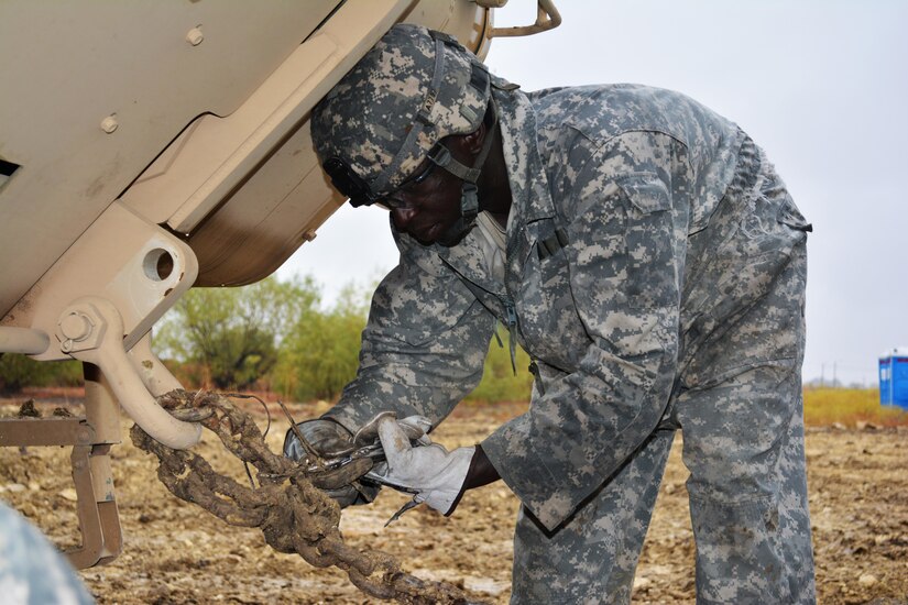 Sgt. Julius Anderson, motor sergeant, 546th Area Support Medical Company, secures the tow chain to a vehicle during the Wheeled Vehicle Recovery Course at Regional Training Site Maintenance-Fort Hood, Oct. 22, 2015. The course teaches Army mechanics how to properly and safely recover and tow vehicles that may be stuck or inoperable.