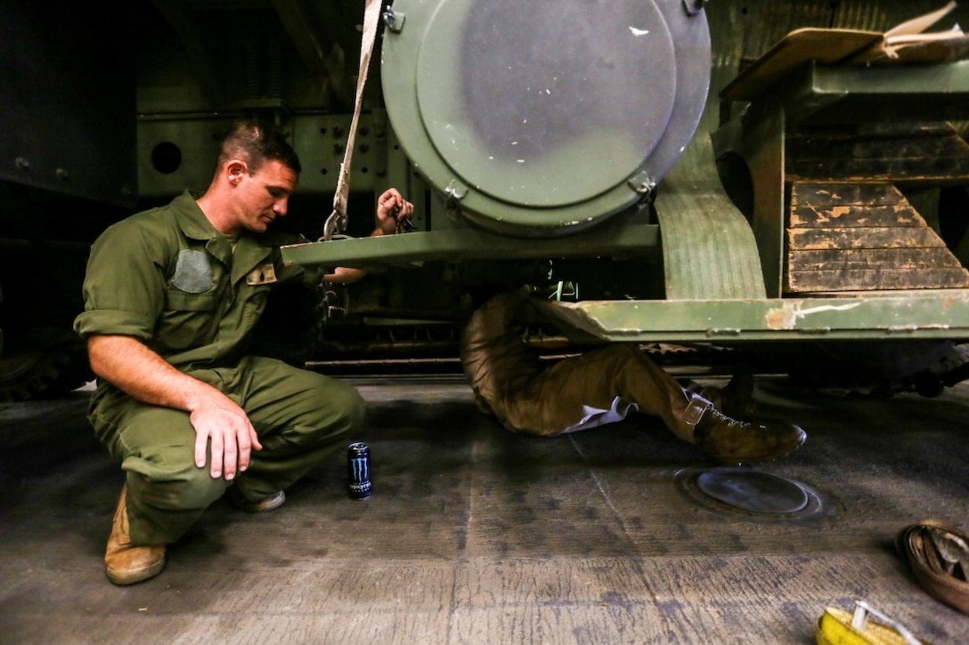 GULF OF ADEN (Oct. 27, 2015) U.S. Marine Sgt. Garrett Kastl, left, assists Lance Cpl. Herman Arreola with first-echelon preventative maintenance checks and services on a Medium Tactical Vehicle Replacement aboard the USS Anchorage (LPD 23).   Kastl and Arreola are motor transportation operators with Combat Logistics Battalion 15, 15th Marine Expeditionary Unit.   The 15th MEU, embarked on the ships of the Essex Amphibious Ready Group, is deployed to maintain regional security in the U.S. 5th Fleet area of operations.  (U.S. Marine Corps photo by Sgt. Jamean Berry/Released)