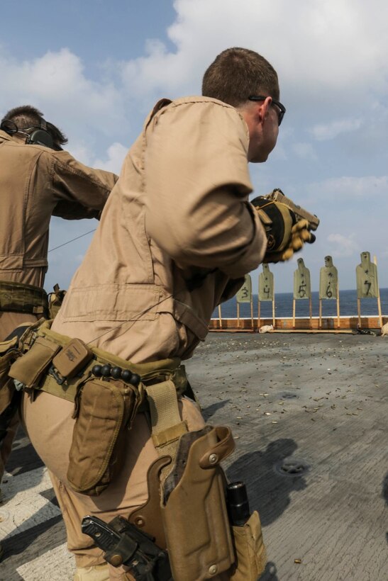 GULF OF ADEN (Oct. 28, 2015) A U.S. Marine with the 15th Marine Expeditionary Unit’s Force Reconnaissance Detachment readies to fire his M45 1911 A1 pistol during a deck shoot aboard the USS Anchorage (LPD 23).  The 15th MEU, embarked on the ships of the Essex Amphibious Ready Group, is deployed to maintain regional security in the U.S. 5th Fleet area of operations. (U.S. Marine Corps photo by Sgt. Jamean Berry/Released)