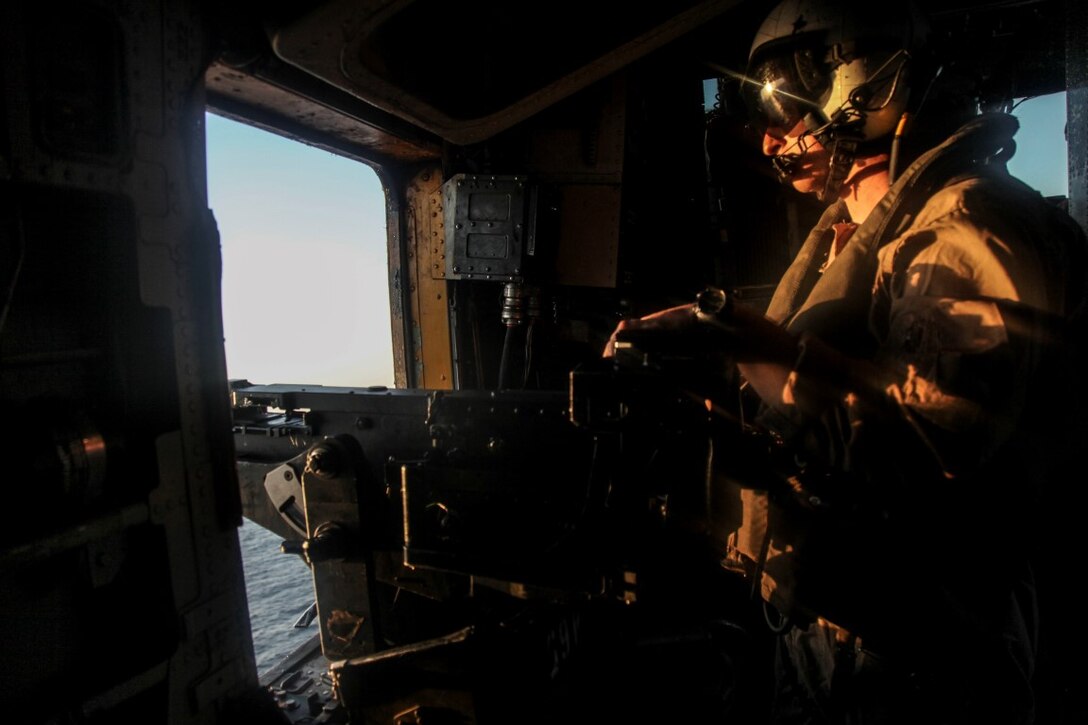 GULF OF OMAN (Oct. 29, 2015) U.S. Marine Sgt. Trevor Adams checks for targets while flying in a CH-53E Super Stallion. Adams is a crew chief with Medium Marine Tiltrotor Squadron 161 (Reinforced), 15th Marine Expeditionary Unit. The 15th MEU, embarked aboard the ships of the Essex Amphibious Ready Group, is deployed to maintain regional security in the U.S. 5th Fleet area of operations. (U.S. Marine Corps photo by Cpl. Elize McKelvey/Released)