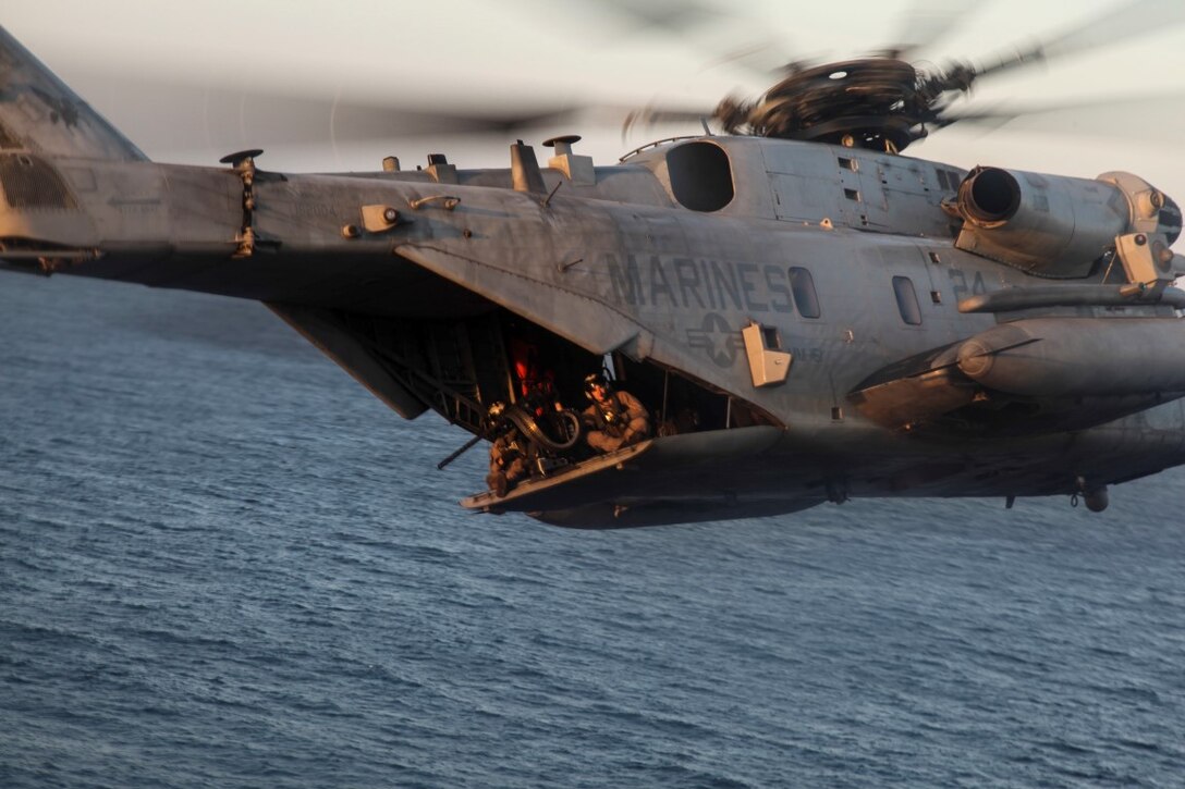 GULF OF OMAN (Oct. 29, 2015) U.S. Marines fly by in a CH-53E Super Stallion during an aerial-gunnery exercise with Medium Marine Tiltrotor Squadron 161 (Reinforced), 15th Marine Expeditionary Unit. The 15th MEU, embarked aboard the ships of the Essex Amphibious Ready Group, is deployed to maintain regional security in the U.S. 5th Fleet area of operations. (U.S. Marine Corps photo by Cpl. Elize McKelvey/Released)