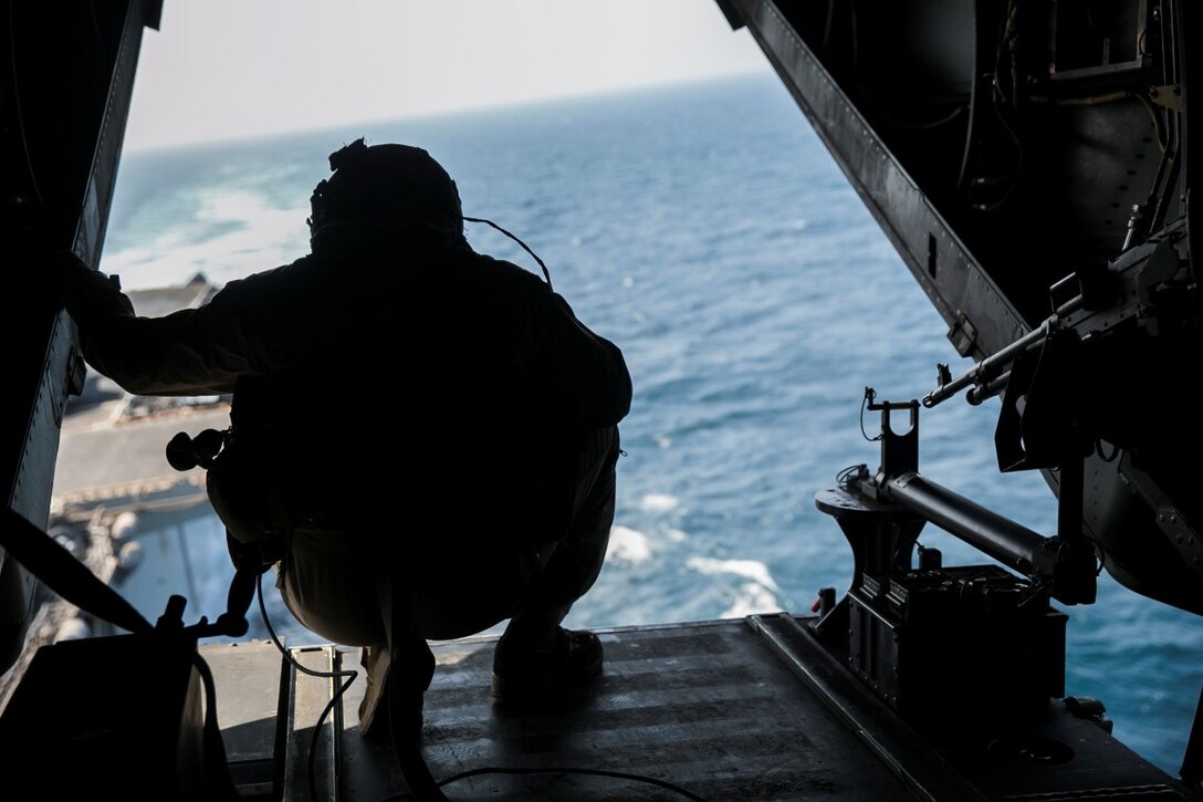 GULF OF OMAN (Oct. 29, 2015) U.S. Marine Cpl. Mitchell Hintz watches as he departs the amphibious assault ship USS Essex (LHD 2) aboard an MV-22B Osprey. Hintz is a crew chief with Marine Medium Tiltrotor Squadron 161 (Reinforced), 15th Marine Expeditionary Unit. The Marines practiced shooting an M240 medium machine gun at targets in the water to stay familiar with the weapon system. The 15th MEU, embarked on the ships of the Essex Amphibious Ready Group, is deployed to maintain regional security in the U.S. 5th Fleet area of operations. (U.S. Marine Corps photo by Sgt. Anna Albrecht/Released)