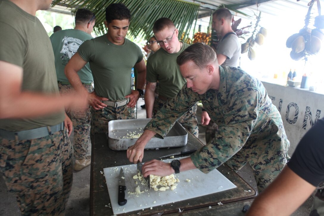 Sgt. Craig Matz, an explosive ordnance disposal Marine for Koa Moana 15-3, helps with a Tahitian meal during cultural events in French Polynesia, Oct. 1. Koa Moana provided an opportunity for cultural exchange among other objectives like enhanced senior military leader engagements between allied and partner nations.