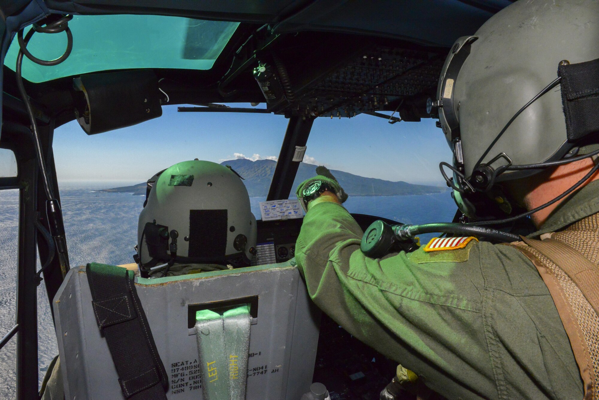 The crew of a UH-1N Huey watch as they approach an island off the coast of Tokyo, Japan, Oct. 28, 2015.The crew delivered simulated medical supplies to Miakejima Island showcasing Yokota’s ability to augment the Tokyo Metropolitan Government’s disaster relief efforts. (U.S. Air Force photo by Airman 1st Class Elizabeth Baker/Released)