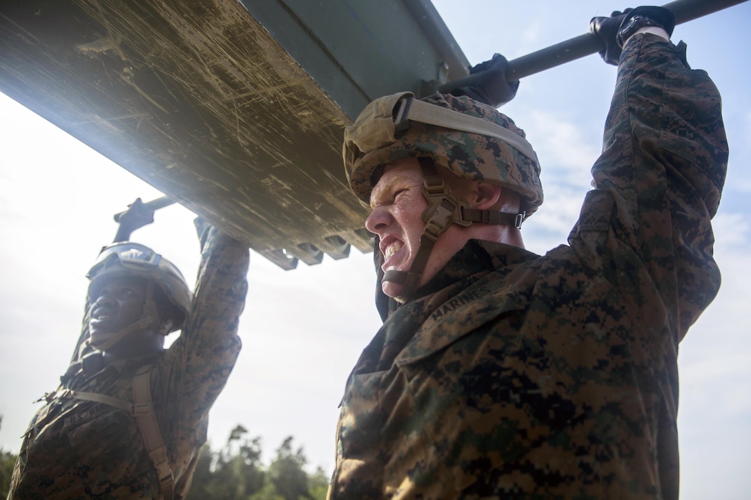 U.S. Marine Corps Lance Cpl. Anthony C. Merriman, right, lifts part of a two-story bridge during Blue Chromite 16 on Camp Hansen, Okinawa, Japan, Oct. 30, 2015. The heaviest piece of equipment lifted throughout the process weighed 600 pounds. Merriman is assigned to the 9th Engineer Battalion, 3rd Marine Logistics Group, 3rd Marine Expeditionary Force. U.S. Marine Corps photo by Cpl. Tyler Giguere