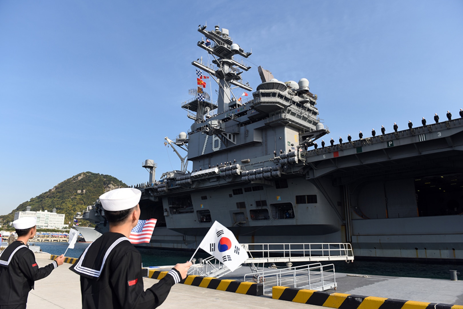 BUSAN, Republic of Korea, (October 30, 2015) Sailors assigned to the Nimitz class aircraft carrier USS Ronald Reagan (CVN 76), receive a welcome from Republic of Korea (ROK) sailors as it pulls into Busan. Reagan is the Navy's only forward deployed aircraft carrier and is conducting a scheduled port visit while participating in bilateral training with the ROK Navy to strengthen the U.S.-ROK alliance and improve regional stability. Ronald Reagan and its embarked air wing, Carrier Air Wing (CVW) 5, provide a combat ready force that protects and defends the collective maritime interests of the U.S. and its allies and partners in the Indo-Asia-Pacific region. 
