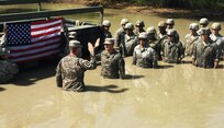 Sgt. Luis Suarez, a student enrolled in the Wheeled Vehicle Recovery Course at Regional Training Site Maintenance-Fort Hood, Texas, takes the oath of reenlistment administered by his company commander Capt. Andrew Schwilk, E Company 227th Aviation Regiment, at the school’s mire pit April, 2015. 
Suarez said, he reenlisted in the pit to give Schwilk, who attained the Additional Skills Identifier earlier in his career, an opportunity to go back to his muddy roots and to motivate other Wheeled vehicle mechanics to earn the ASI. 