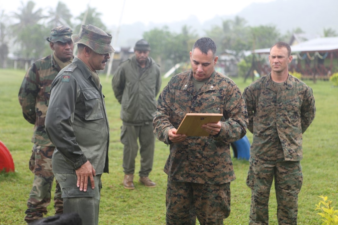 Lt. Col. Demetrius Bolduc, commanding officer for KOA MOANA 15-3, presents an award to Maj. Henry Macomber, a commander with the Republic of Fiji Military Force during a ceremony following a training exercise between the two nations in Namosi Province, Fiji, Oct. 15. Marines and members of the RFMF conducted jungle training, jungle survival exercises and participated in community rebuilding projects.