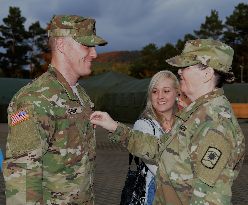 Army Reserve Staff Sgt. Linda Maybury promotes her son, Army Reserve Sgt. 1st Class David Maybury, during his promotion ceremony Oct. 25, 2015 at Panzer Kaserne, Kaiserslautern, Germany. David is an active Guard Reserve Soldier assigned to the 7th Mission Support Command Headquarters. Linda also is an AGR assigned to the 361st Civil Affairs Brigade. (U.S. Army photo by Visual Information Specialist Elisabeth Paque/Released)