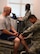 Lt. Col. Hans Meissnest, 90th MDOS Physical Medicine flight commander, performs an examination on Staff Sgt. Todd Hufford, 90th Security Forces Squadron. while Senior Airman Felicia Sanchez, 90th MDOS Physical Medicine technician, takes down notes Oct. 28, 2015, in a physical therapy examination room in the Freedom Hall Fitness Center on F.E. Warren Air Force Base, Wyo. After the examination, a technician, such as Sanchez, will help Airmen with exercises and stretches to help relieve the pain. (U.S. Air Force photo by Senior Airman Brandon Valle)