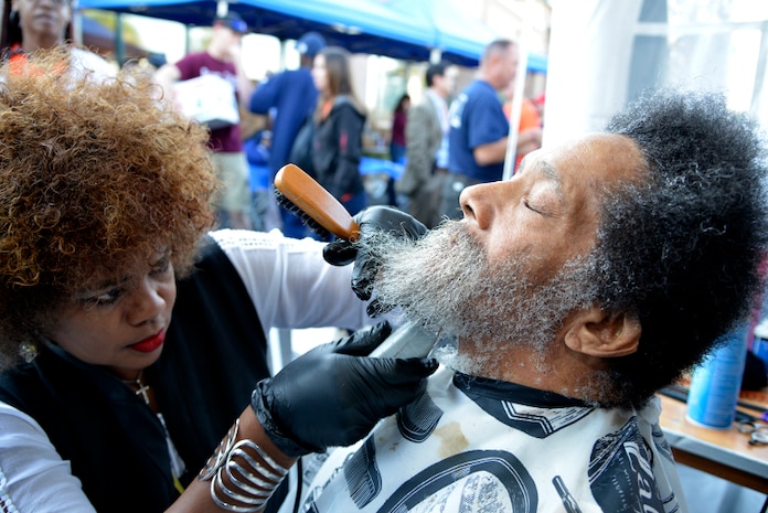 Samuel Davis, a Veteran of the United States Air Force, gets his hair and beard trimmed by Tina, a barber with Howard’s Barber & Styling College, during the Veteran Stand Down at the VA Community Resource and Referral Center on Friday, Oct. 30, 2015. (VA Photo by James Arrowood)