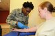 Airman 1st Class Chinyelu Umeokolo , a medical technician with the 127th Medical Group, draws blood from Staff Sgt. Jaimee Blaharski at Selfridge Air National Guard Base, Mich., Oct. 18, 2015. Umeokolo was born in Nigeria and now serves in the Air National Guard as a way to say “thank you” to America.  (U.S. Air National Guard photo by Staff Sgt. Samara Taylor)