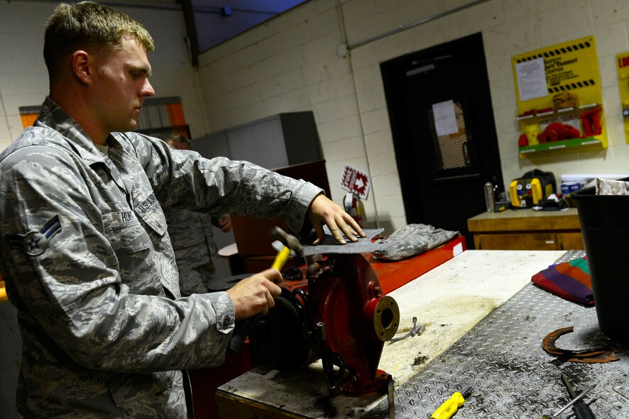 U.S. Air Force Airman 1st Class Greyson Hunt, 20th Civil Engineer Squadron Heating, Ventilation, and Air Conditioning apprentice, shapes a gasket onto a hot water circulating pump using a ball-peen hammer at Shaw Air Force Base, S.C., Oct. 30, 2015. A gasket is placed between two pieces of equipment before merging to prevent any possible leak. (U.S. Air Force photo by Airman 1st Class Christopher Maldonado/Released)