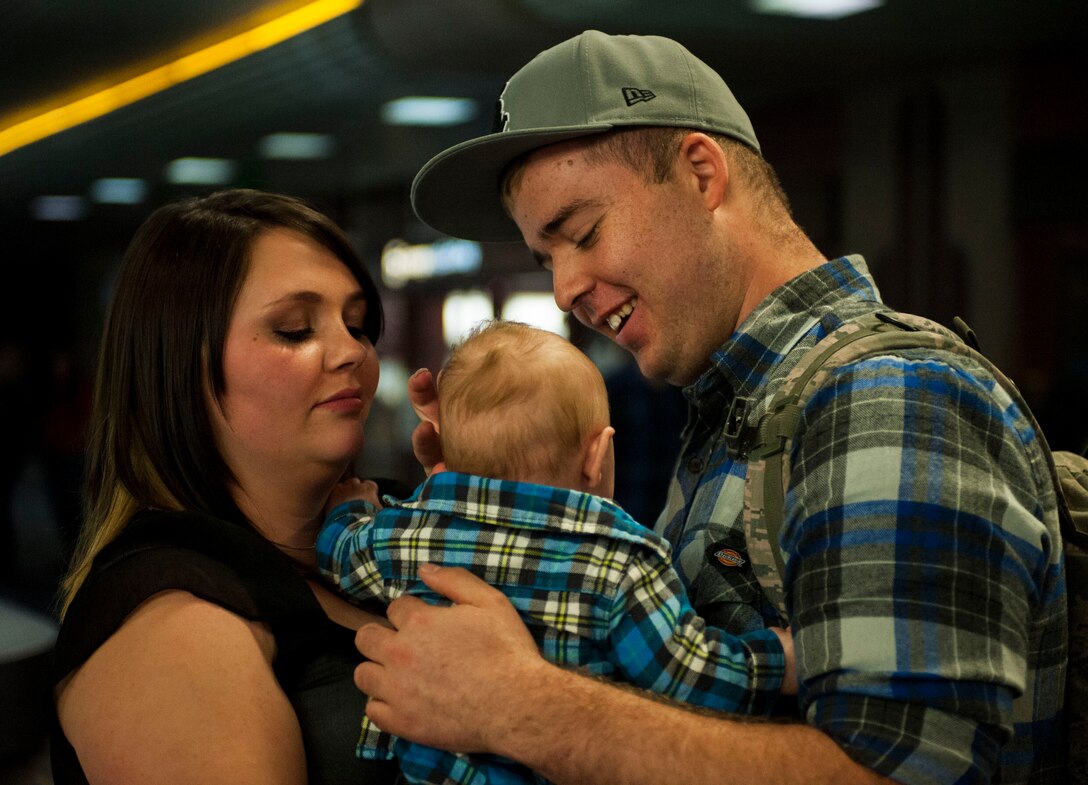 Senior Airman Tyler Havel, 926th Security Forces Squadron member, embraces his son with his wife after returning from a deployment at McCarran International Airport in Las Vegas, Oct. 22, 2105. Havel returned home from a seven-month deployment to Southwest Asia with fellow 926th SFS members. (U.S. Air Force photo by Airman 1st Class Jake Carter)