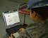 U.S. Air Force Airman 1st Class Maegen Correll, 100th Maintenance Squadron sheet metal apprentice, checks a technical order Oct. 21, 2015, as a safety spotter, ensuring all necessary steps are followed correctly when placing a decal of the 100th Air Refueling Wing’s “Square D” on the tail of a KC-135 Stratotanker on RAF Mildenhall, England. The jet, formerly from McConnell Air Force Base, Kan., has been reassigned to RAF Mildenhall and underwent a full isochronal inspection. The jet has now been repainted and given the “Square D” markings. (U.S. Air Force photo by Karen Abeyasekere/Released)