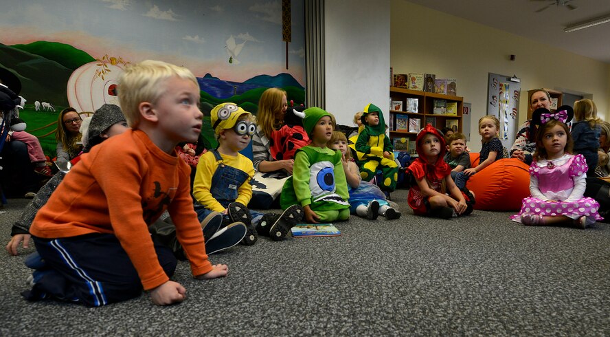 Kaiserslautern Military Community children listen to a story during the Ramstein Library’s Spooky Story Time Oct. 29, 2015, at Ramstein Air Base, Germany. The children listened to two Halloween-themed stories, colored a picture and painted their handprints on pumpkins. (U.S. Air Force photo/Airman 1st Class Tryphena Mayhugh)