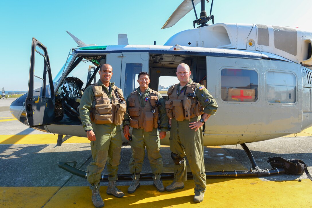 Capt. Brandon Jones and 1st Lt. Vicente Vasquez, 459 Airlift Squadron UH-1N Huey pilots and Staff Sgt. Christopher Rector, 459 AS special missions aviator, pose for a photo at Yokota Air Base, Japan, Oct. 28, 2015. The crew was assembled to perform a Tokyo Metropolitan Government disaster relief exercise on Miakejima Island just off the coast of Tokyo. (U.S. Air Force photo by Airman 1st Class Elizabeth Baker/Released)