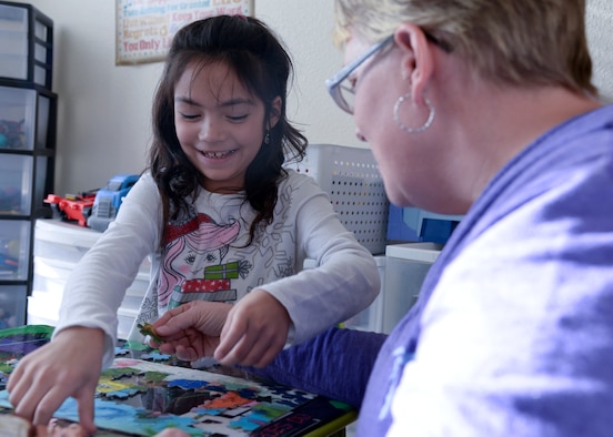 Whitney Barber, 8, daughter of Staff Sgt. Katherine Tedrow, 90th Missile Wing Protocol, works with Tara Firos, Extended Child Care provider, to finish a puzzle Oct. 29, 2015, in Firos’s home on F.E. Warren Air Force Base, Wyo. Firos is one of eight child care providers in the Family and Extended Child Care programs. (U.S. Air Force photo by Airman 1st Class Malcolm Mayfield)