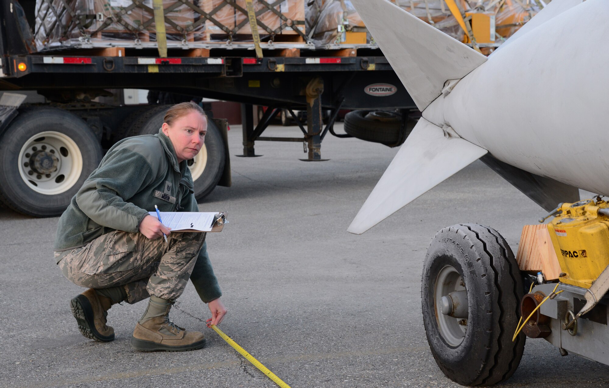 U.S. Air Force Tech. Sgt. Rebecca Morin, the 354th Logistics Readiness Squadron noncommissioned officer in charge of air terminal operations, measures a fuel tank Oct. 28, 2015, at Eielson Air Force Base, Alaska. Morin verified the fuel tank length to find the center of balance for the cargo. (U.S. Air Force photo by Airman 1st Class Cassandra Whitman/Released)