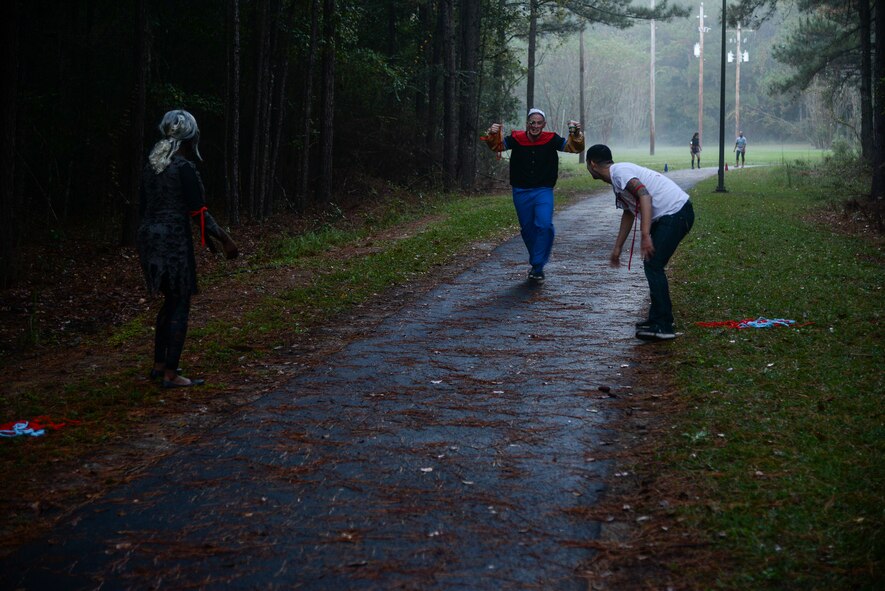 “Zombies” chase after a buff sailor during a Zombie Run Oct. 30, 2015, at Moody Air Force Base, Ga. If runners had their flags taken by the “zombies” they had to stay in the zombie zone until they de-flagged another runner or five minutes passed. (U.S. Air Force photo by Airman 1st Class Janiqua P. Robinson/Released)