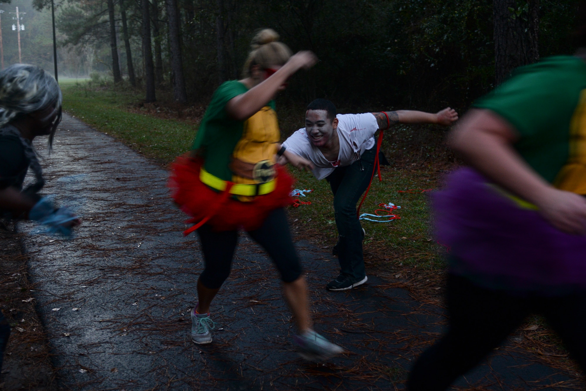 ”Zombies” try to take participants flags, or lives, during a Zombie Run Oct. 30, 2015, at Moody Air Force Base, Ga. “Zombies” could only give chase when runners went off the paved running trail. (U.S. Air Force photo by Airman 1st Class Janiqua P. Robinson/Released)