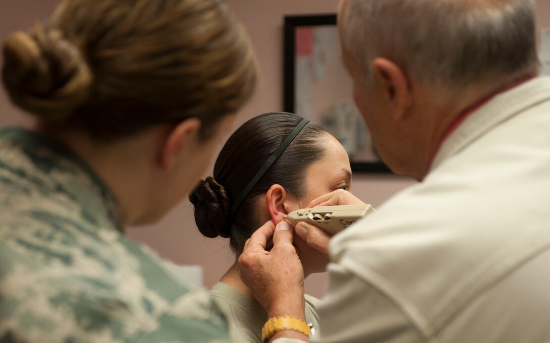 Dr. Joseph Helms, Helms Medical Institute president, demonstrates how to use a pointer plus on a patient at the Mike O’Callaghan Federal Medical Center on Nellis Air Force Base, Nev., Oct. 26, 2015. A pointer plus helps find the most sensitive points on the ear. (U.S. Air Force photo by Senior Airman Mikaley Kline)