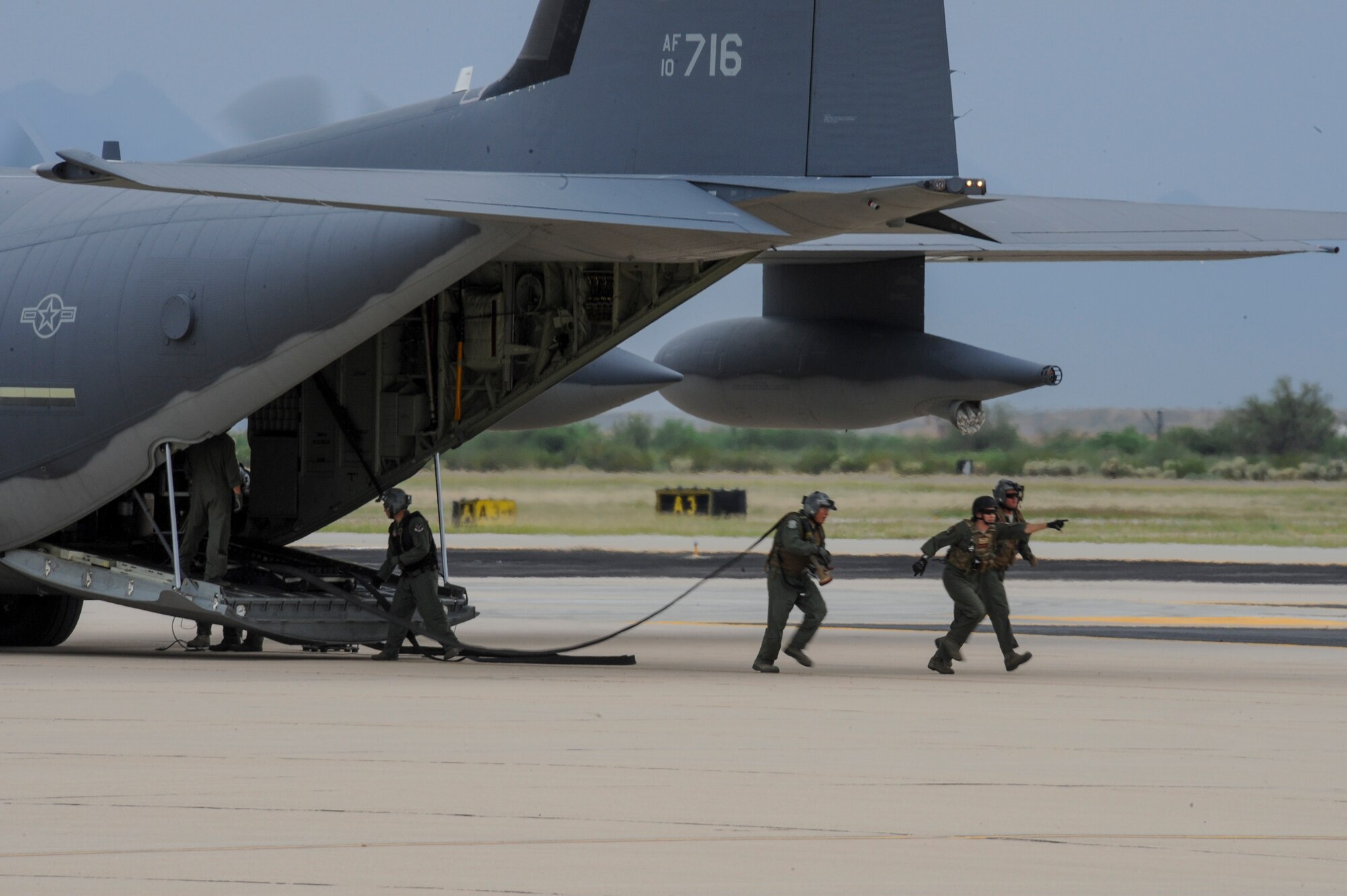 U.S. Airmen with the 355th Logistics Readiness Squadron and 563rd Operations Support Squadron Forward Area Refueling Point team deploy a FARP hose from an HC-130J Combat King II during FARP training at Davis-Monthan Air Force Base, Ariz., Oct. 15, 2015. The FARP capability allows for projection of combat power and rescue forces from an infinite number of locations around the world. (U.S. Air Force photo by Senior Airman Chris Massey/Released)