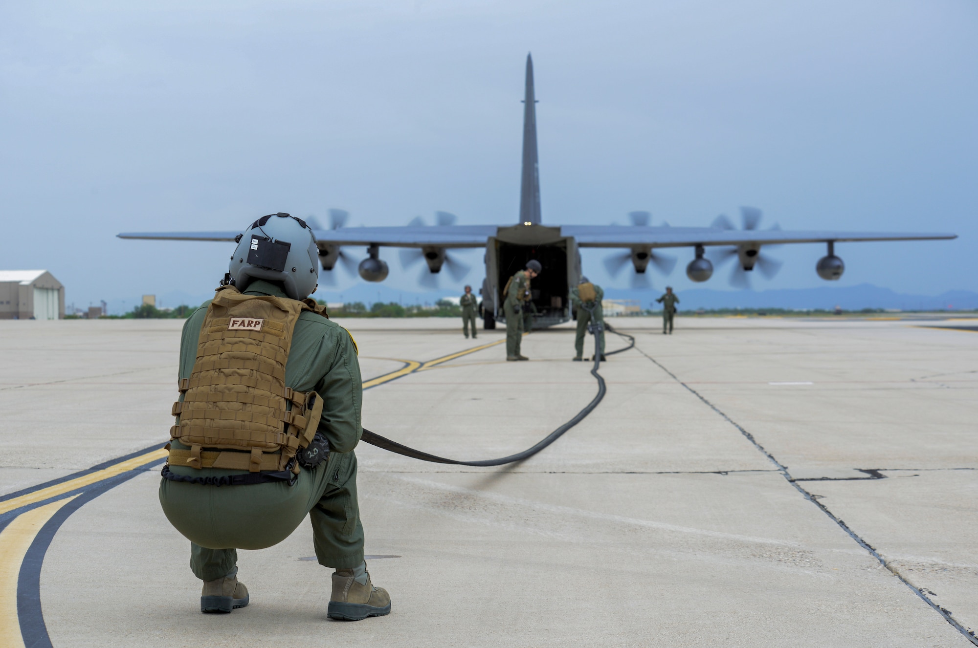 U.S. Air Force Staff Sgt. Timothy Quinn, 355th Logistics Readiness Squadron and 563rd Operations Support Squadron Forward Area Refueling Point team member, anchors a fuel hose connected to an HC-130J Combat King II to help clear it of fuel after training at Davis-Monthan Air Force Base, Ariz., Oct. 15, 2015.  The FARP capability allows for projection of combat power and rescue forces from an infinite number of locations around the world. (U.S. Air Force photo by Senior Airman Chris Massey/Released)