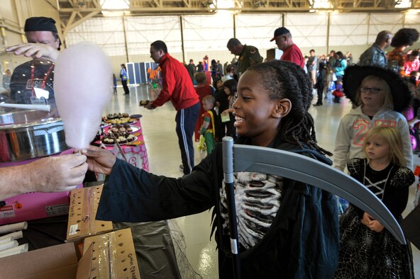 The United Service Organization serves cotton candy to a child during the 2015 Children’s Halloween party Oct. 30, 2015, at Creech Air Force Base, Nevada. Activities for the day included cornhole, trunk or treat, book reading, free food, bag decoration, and a magic show. (U.S. Air Force photo by Senior Airman Adarius Petty/Released)
