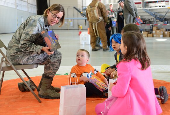 Lt. Col. Mackenzie Shultz, 432nd Aircraft Maintenance Squadron commander, reads to a group of children during the 2015 children's halloween party Oct. 30, 2015, at Creech Air Force Base, Nevada. The event gave children the opportunity for a day of fun with their Air Force parents and other families. (U.S. Air Force photo by Airman 1st Class Christian Clausen/Released)