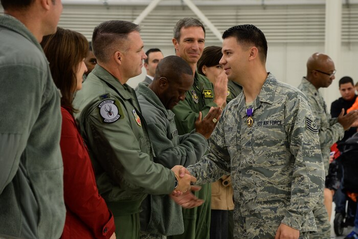 Tech. Sgt. Jesus Soto, an Electronic Warfare Specialist with the 388th Component Maintenance Squadron, shakes hands with Team Hill leadership after receiving a Purple Heart at Hill Air Force Base, Utah, Oct. 30, 2015. Soto was injured in 2005 while deployed with the 1st Security Forces Squadron to Forward Operating Base Speicher near Tikrit, Iraq. While there, he provided security to U.S. convoys and foreign national supply trucks. (U.S. Air Force photo by R. Nial Bradshaw/Released)
