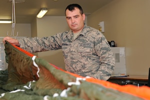 Senior Airman Adam McMann, 127th Operations Group aircrew flight equipment technician, inspects a parachute from an ejection seat at Selfridge Air National Guard Base, Mich., Oct. 17, 2015. Each line connecting the canopy to the harness is precisely measured, if the length is too long or too short the entire line is replaced. (U.S. Air National Guard photo by Senior Airman Ryan Zeski/Released)