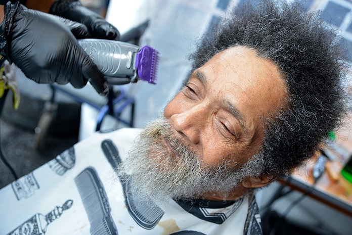 Samuel Davis, a Veteran of the United States Air Force, gets his hair and beard trimmed by Tina, a barber with Howard’s Barber & Styling College, during the Veteran Stand Down at the VA Community Resource and Referral Center on Friday, Oct. 30, 2015. (VA Photo by James Arrowood)