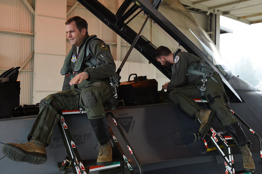 Maj. Matt Russell (left), 416th Flight Test Squadron F-16 Falcon pilot, and Christian Turner, 412th Test Squadron aerial photographer, get into an F-16 Falcon on the McChord Field flightline Oct. 27, at Joint Base Lewis-McChord, Wash. Russell and Turner, stationed out of Edwards Air Force Base, are temporarily located at McChord in support of the KC-46 Pegasus flight test program. (U.S. Air Force photo/Senior Airman Naomi Shipley) 