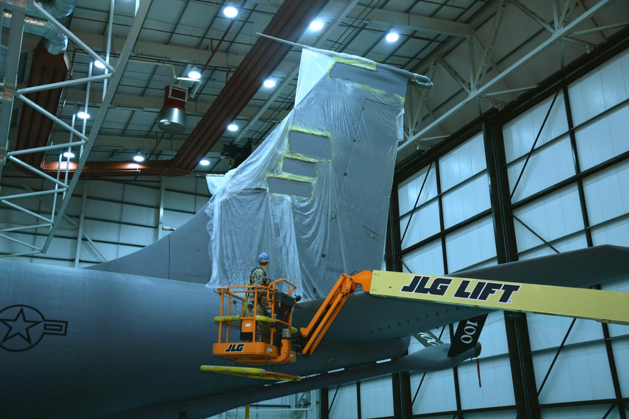 A U.S. Air Force Airman from the 100th Maintenance Squadron checks the primer under protective plastic on the tail of a KC-135 Stratotanker Oct. 21, 2015, to see if it’s ready for the next stage of the painting process, on RAF Mildenhall, England. The tanker was reassigned from McConnell Air Force Base, Kan., and arrived in September, when the tail was removed in order to repair a broken part. Once replaced, the aircraft was primed and repainted, ready for application of the 100th Air Refueling Wing’s Square D, which honors the base’s heritage with the 100th Bombardment Group. (U.S. Air Force photo by Karen Abeyasekere/Released)