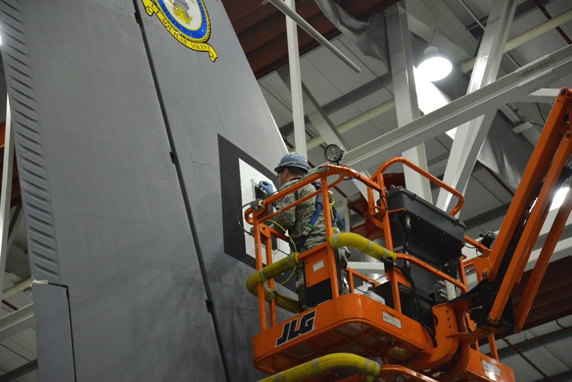 U.S. Air Force Staff Sgt. Adam Denham, 100th Maintenance Squadron aircraft structural maintenance craftsman, applies sealer to the edges of the Square D decal on aircraft tail number 10267 to ensure it doesn’t detach during flight Oct. 21, 2015, on RAF Mildenhall, England. After taping around the edges of the Square D, liquid sealant was painted on all the decals. Once hardened, it seals the edges of the decal onto the aircraft. (U.S. Air Force photo by Karen Abeyasekere/Released)