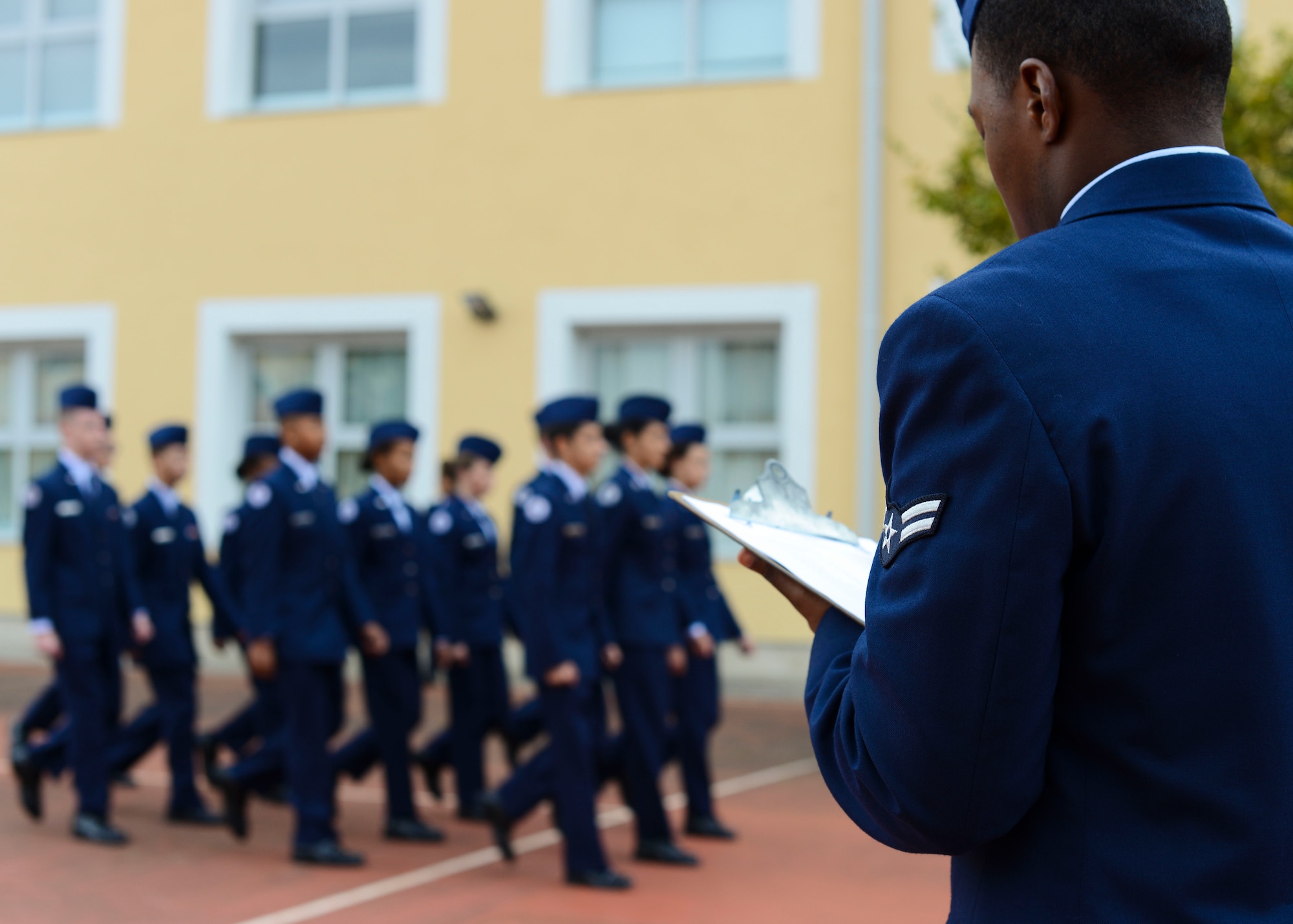 U.S. Air Force Airman 1st Class Aaron Stubbs, 31st Civil Engineer Squadron emergency management journeyman, critiques a marching routine during Aviano High School JROTC Corps Day, Oct. 28, 2016, at Aviano Air Base, Italy. Airmen assessed the cadets’ performances to help improve their routine for a Nov. 14 drill competition. (U.S. Air Force photo by Senior Airman Austin Harvill/Released)