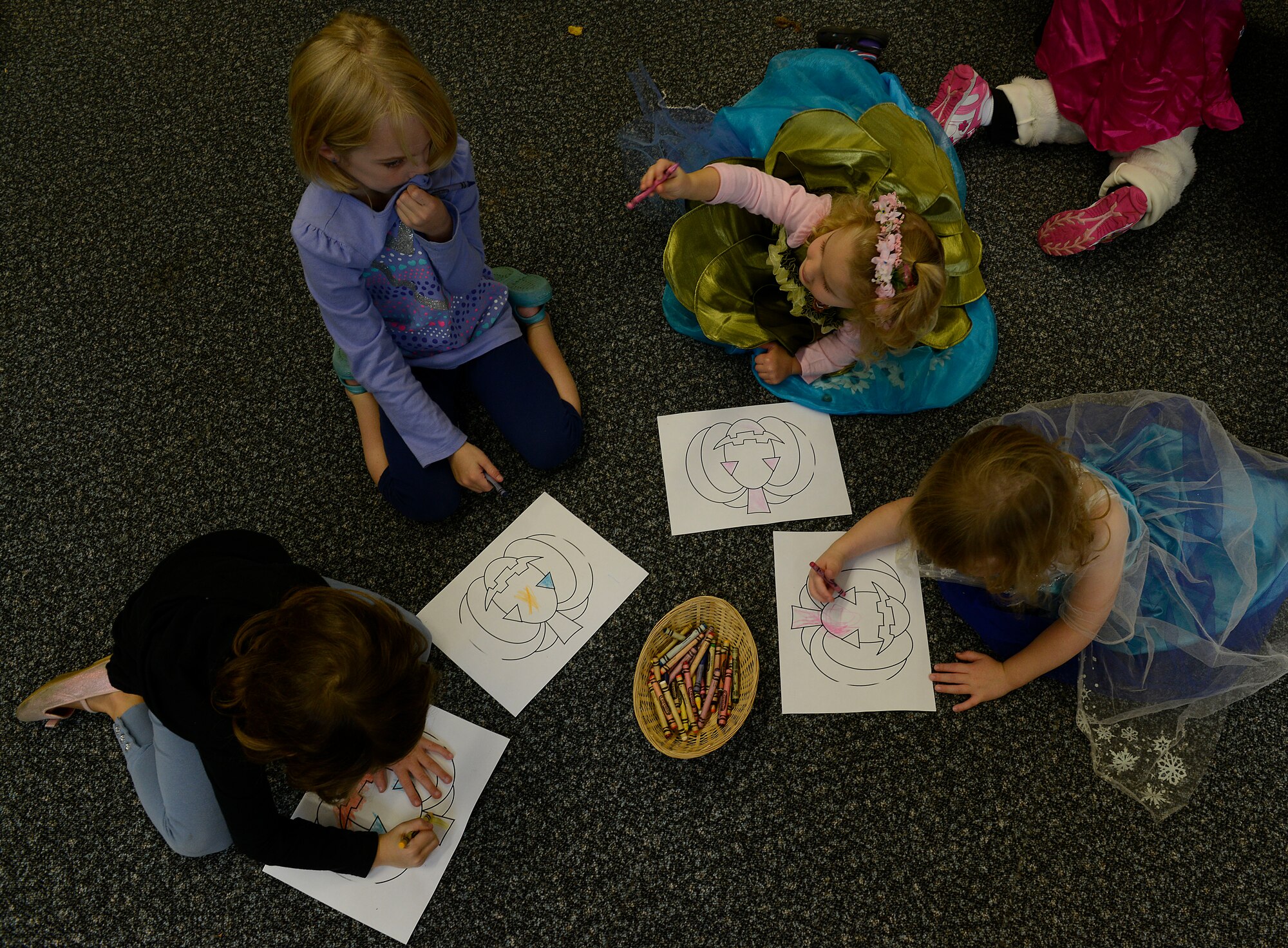 Kaiserslautern Military Community children color in a pumpkin during Ramstein Library’s Spooky Story Time Oct. 29, 2015, at Ramstein Air Base, Germany. The children listened to two Halloween-themed stories, colored a picture and painted their handprints on pumpkins. (U.S. Air Force photo/Airman 1st Class Tryphena Mayhugh)