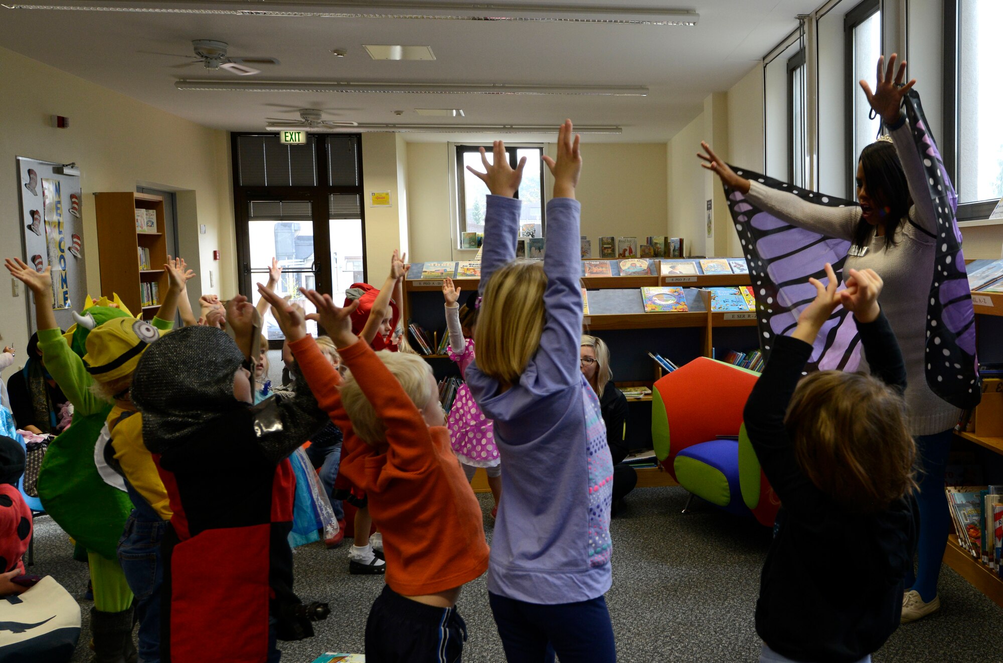 Terina Curtis, library technician at the Ramstein Library, leads children in a song during Spooky Story Time Oct. 29, 2015, at Ramstein Air Base, Germany. After the song, Curtis read two Halloween-themed stories to the children and helped them paint their handprints on pumpkins. (U.S. Air Force photo/Airman 1st Class Tryphena Mayhugh)