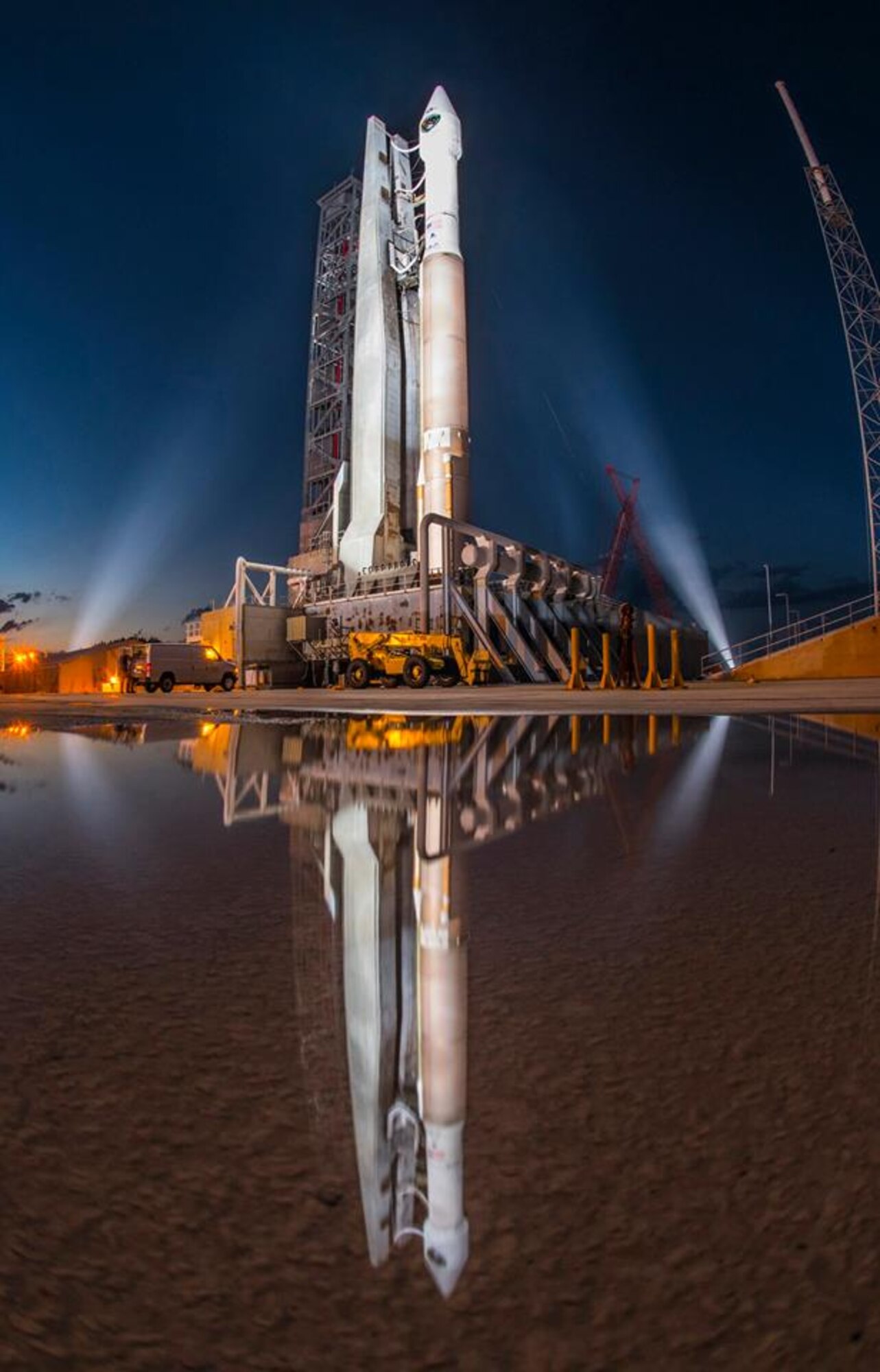 As dusk settles into Friday evening, a United Launch Alliance Atlas V 401 launch vehicle with a Boeing-built GPS IIF-11 satellite encapsulated in its four-meter diameter protective fairing is seen in this mirror image at Space Launch Complex-41 at Cape Canaveral Air Force Station, Fla. The launch window opens Oct. 31 at 12:13 p.m. EDT (9:13 a.m. PDT). (Courtesy photo: ULA)