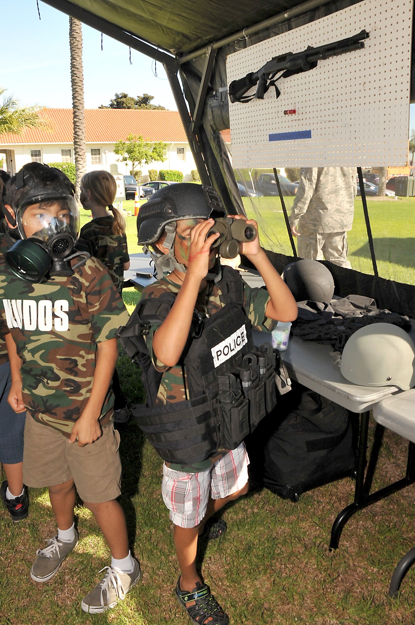 A couple of young warriors try on protective gear such as gas masks, Kevlar vests and night vision goggles used by the 61st Security Forces Squadron during the annual Kids Understanding Deployment Operations event Oct. 24 held on the Los Angeles Air Force Base parade grounds at Fort MacArthur in San Pedro, Calif. More than 150 military, DoD and contractor’s children and teens experienced first-hand what their military parents experience when deployed. (U.S. Air Force photo/Joseph Juarez, Sr.)