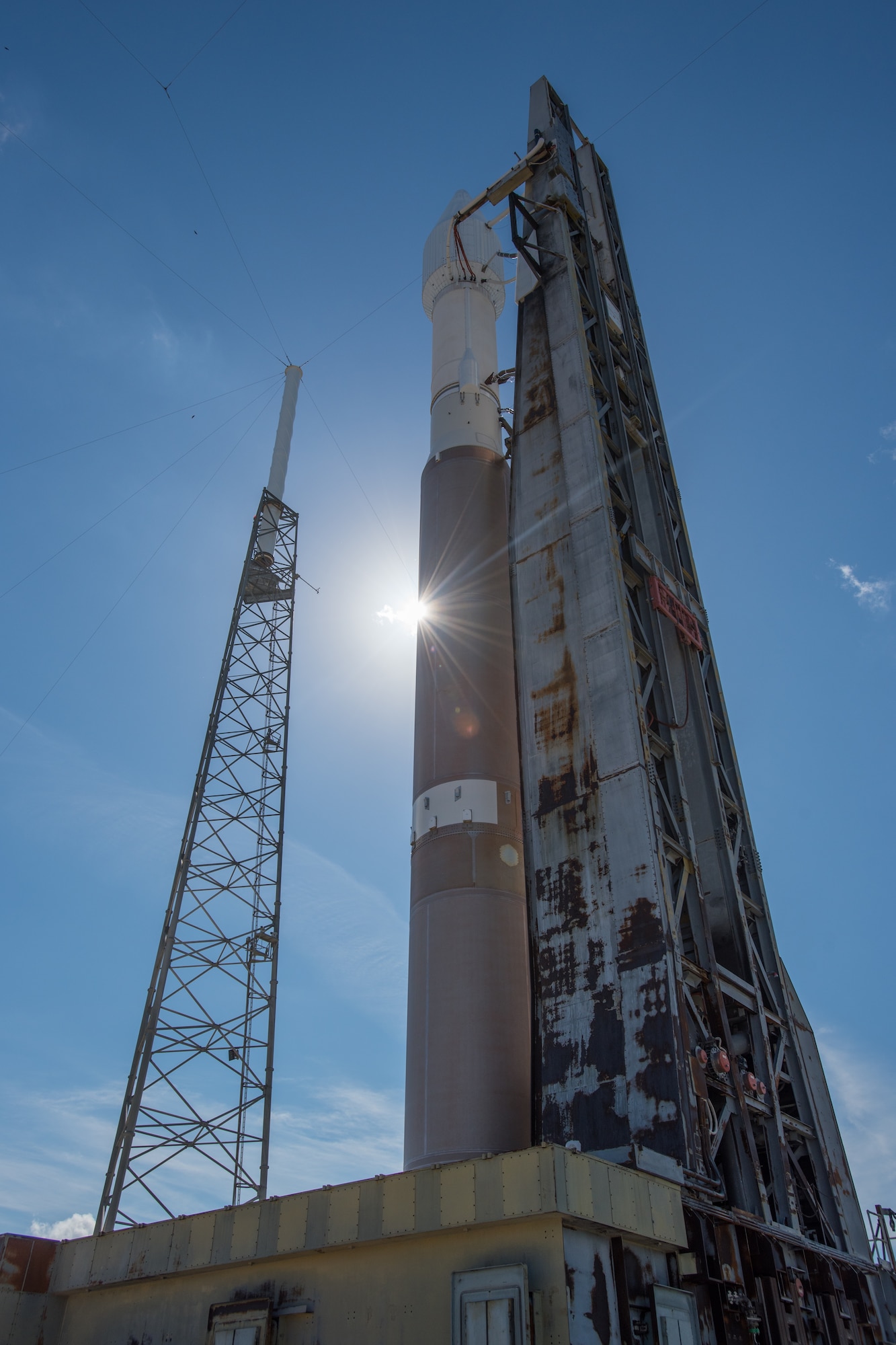 A reverse angle view of the Atlas V 401 launch vehicle with GPS IIF-11 satellite aboard at  Space Launch Complex-41 in anticipation of a Saturday afternoon launch from Cape Canaveral Air Force Station, Fla. The launch window opens Oct. 31 at 12:13 EDT (9:13 a.m. PDT). This is the second to last GPS IIF launch in a series of 12 spacecraft. The gray structure with white mast just to the left of the mobile launch platform is a lightning tower used to protect the launch vehicle and satellite from Florida's notorious thunderstorms and lightning strikes. (Photo courtesy United Launch Alliance).