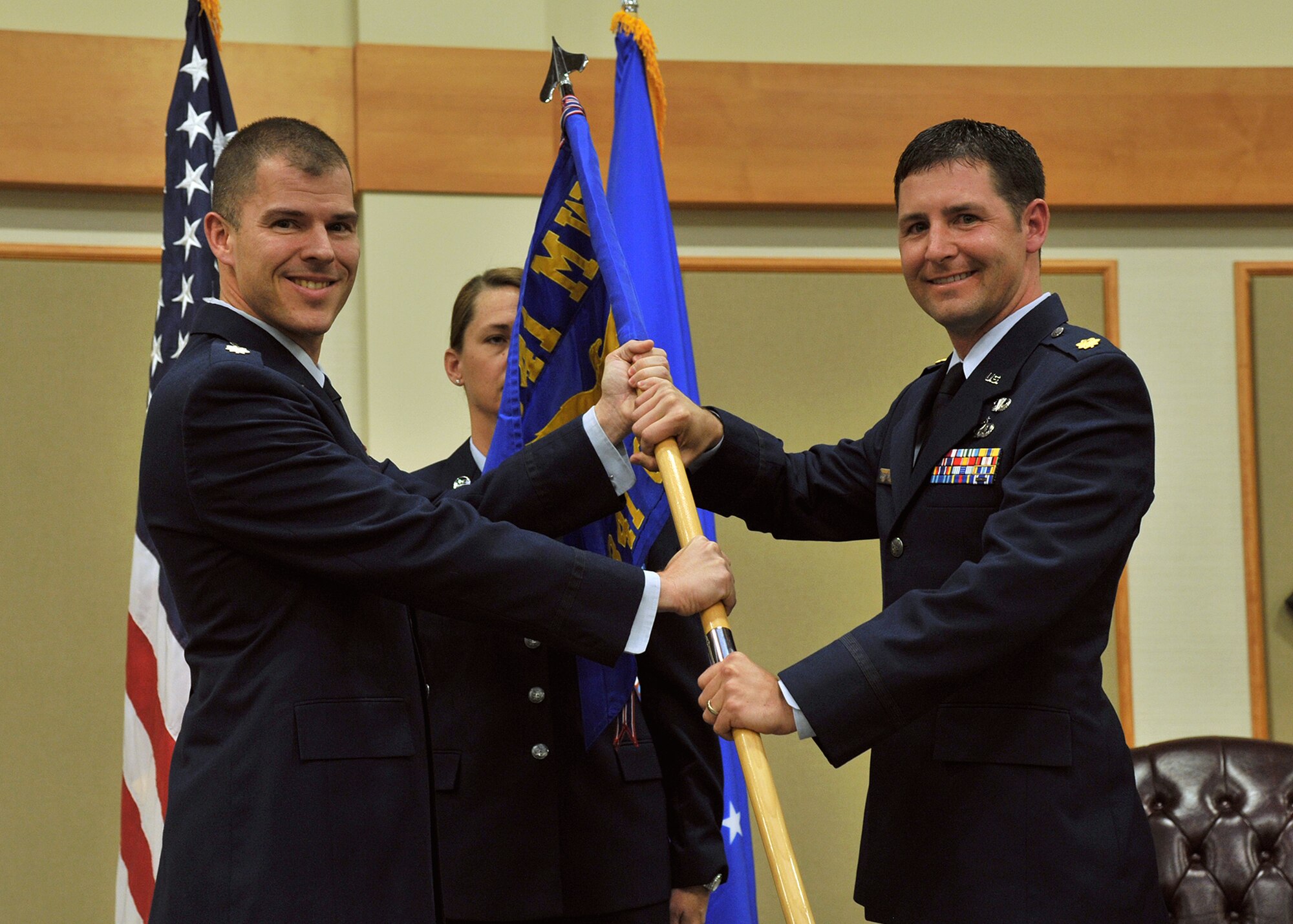 Maj. Jeremiah Kirschman, right, accepts command of the 341st Contracting Squadron from Lt. Col. Scott Fleming, 341st Mission Support Group deputy commander Oct. 29, 2015, at Malmstrom Air Force Base, Mont. Senior Master Sgt. Toni Wiser, 341st CONS superintendent, center, looks on. (U.S. Air Force photo/John Turner)