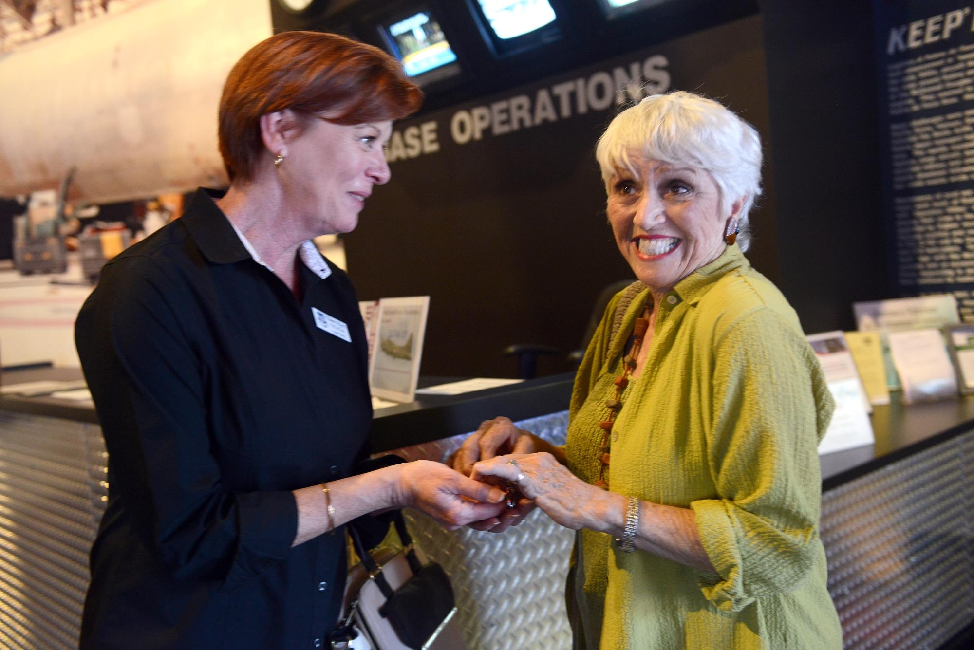Eileen Byrd, 116th Air Control Wing Airman and Family Readiness program manager, presents Lani Czyzewski with her father’s lost military bracelet Oct. 22. (U.S. Air Force photo by Tommie Horton)