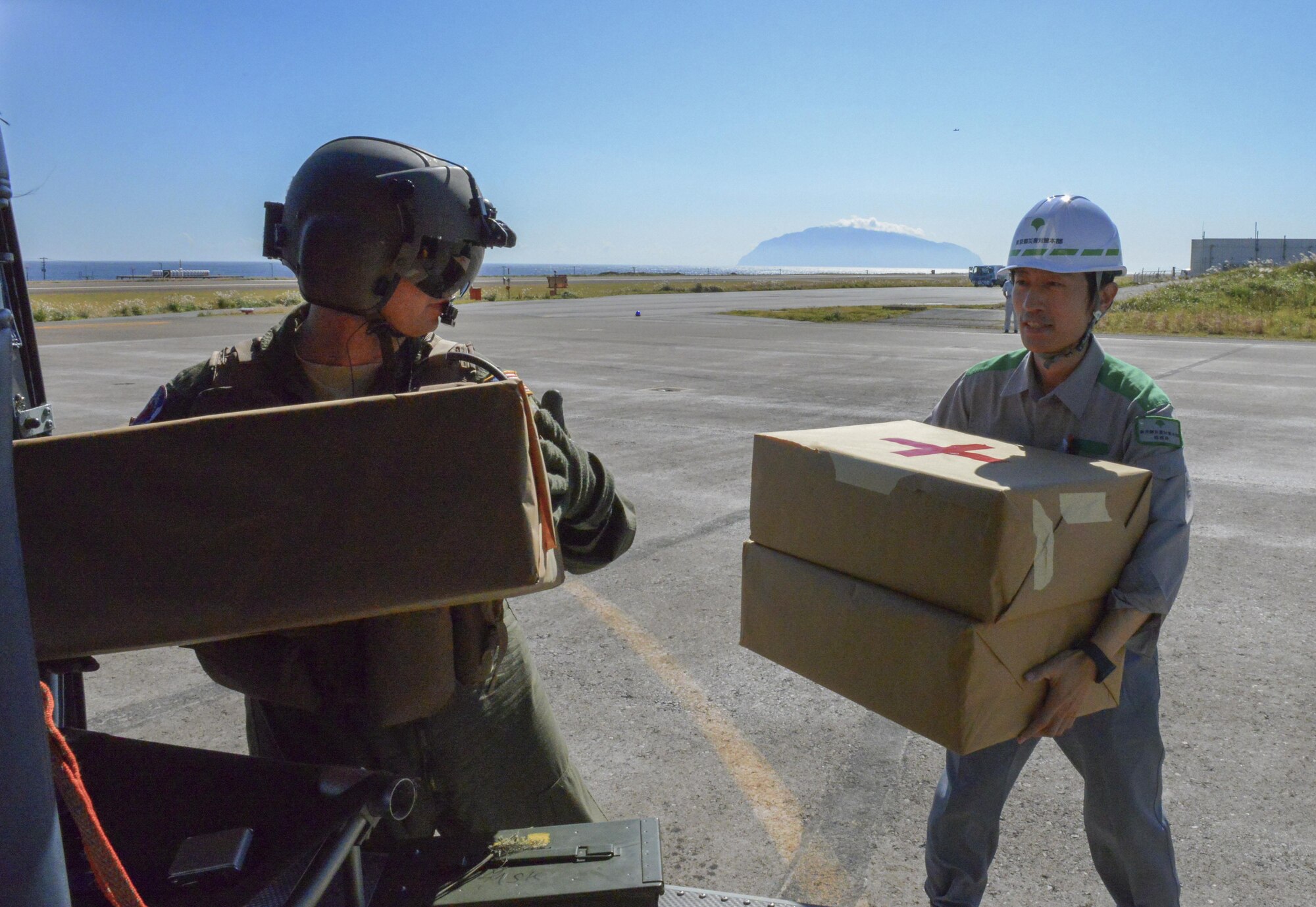 Staff Sgt. Christopher Rector, 459th Airlift Squadron special missions aviator, delivers simulated medical supplies to personnel at Miakejima Airport at Miakejima Island, Japan, Oct. 28, 2015. The United States military performs disaster relief exercises with the Metropolitan Government about twice a year, demonstrating readiness and supporting bilateral operations.  (U.S. Air Force photo by Airman 1st Class Elizabeth Baker/Released)