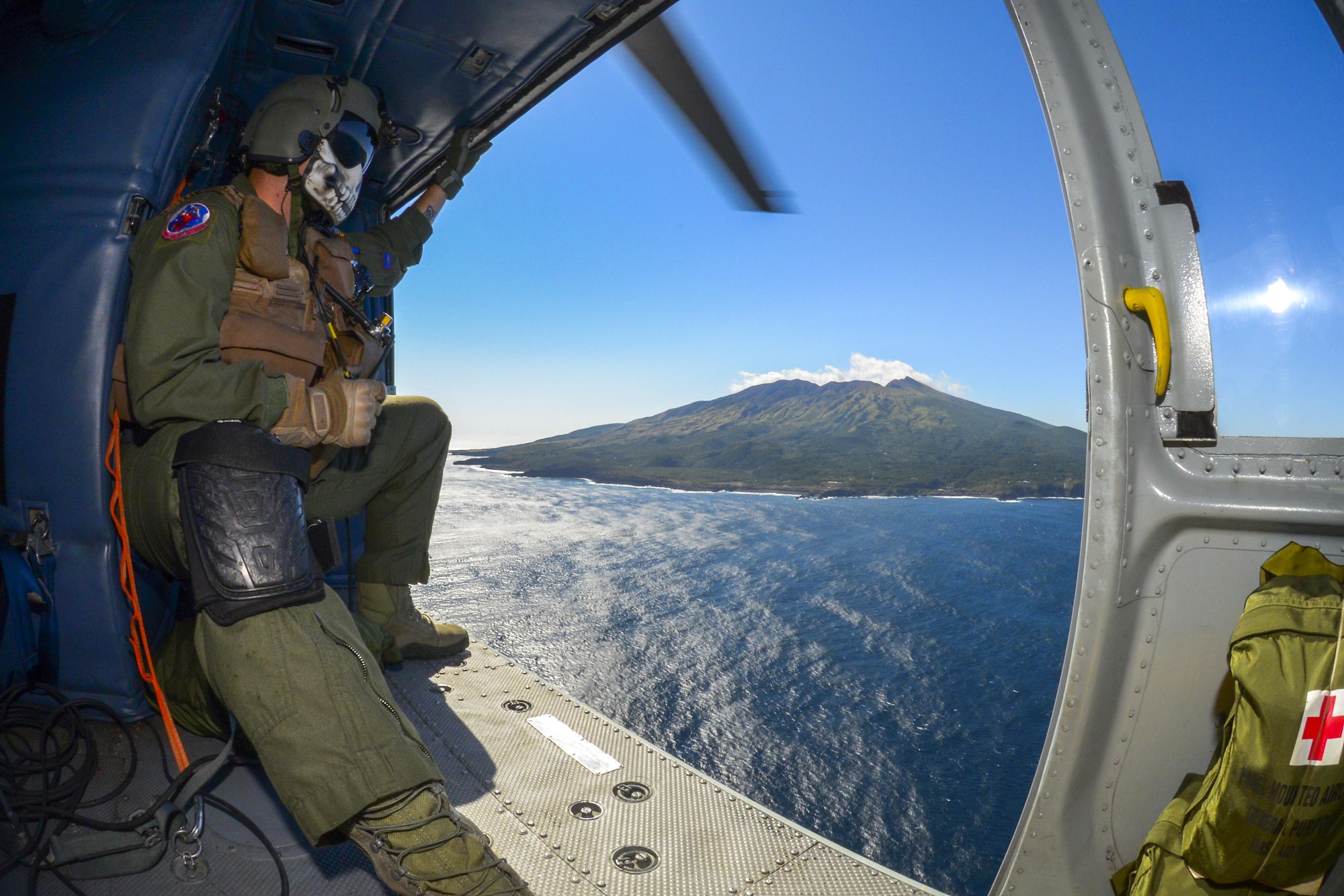 Staff Sgt. Christopher Rector, 459th Airlift Squadron special missions aviator, watches scenery pass off the coast of Tokyo, Japan, Oct. 28, 2015.The crew were required to wear special gear while operating over the ocean, including an emergency survival vest and flight suits designed for warmth in cold water. During the exercise, every precaution was taken to ensure the safety of the crewmembers. (U.S. Air Force photo by Airman 1st Class Elizabeth Baker/Released)
